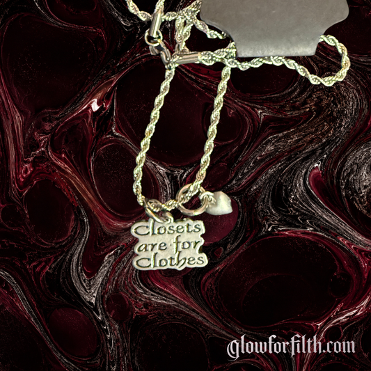 American pewter Closets Are For Clothes necklace with heart accent charm on a stainless steel rope chain displayed against a dark red and black background.