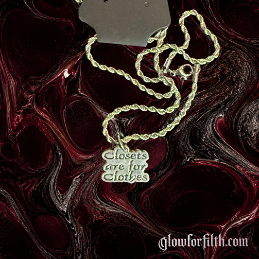 Minimalist American pewter Closets Are For Clothes necklace on a stainless steel rope chain displayed against a dark red and black Glow for Filth background.