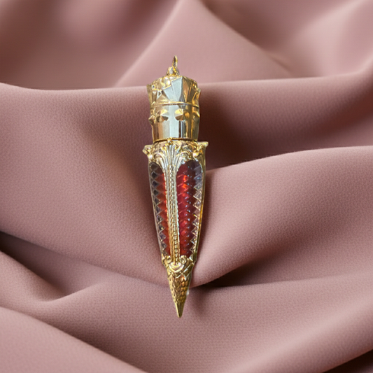 Luxury gothic red lip gloss in ornate gold claw tube displayed against soft blush fabric folds for an editorial beauty campaign aesthetic.