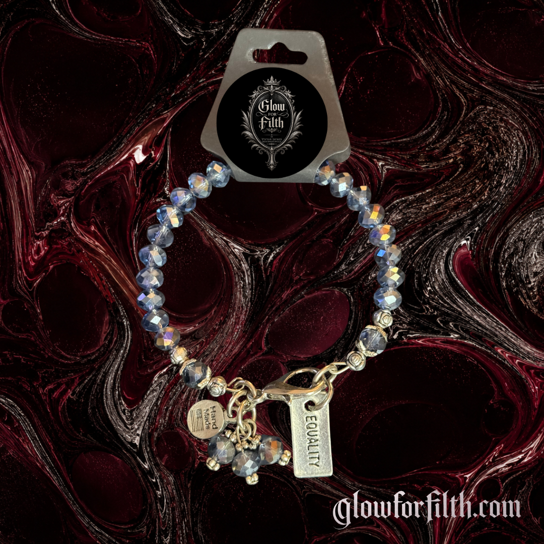 Handcrafted crystal bracelet featuring a lead-free pewter Equality charm and faceted iridescent crystal beads displayed on a gothic burgundy and black marbled background.