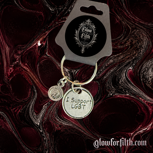 American pewter I Support LGBT keychain with silver-toned finish and accent charm displayed on Glow for Filth branded packaging.