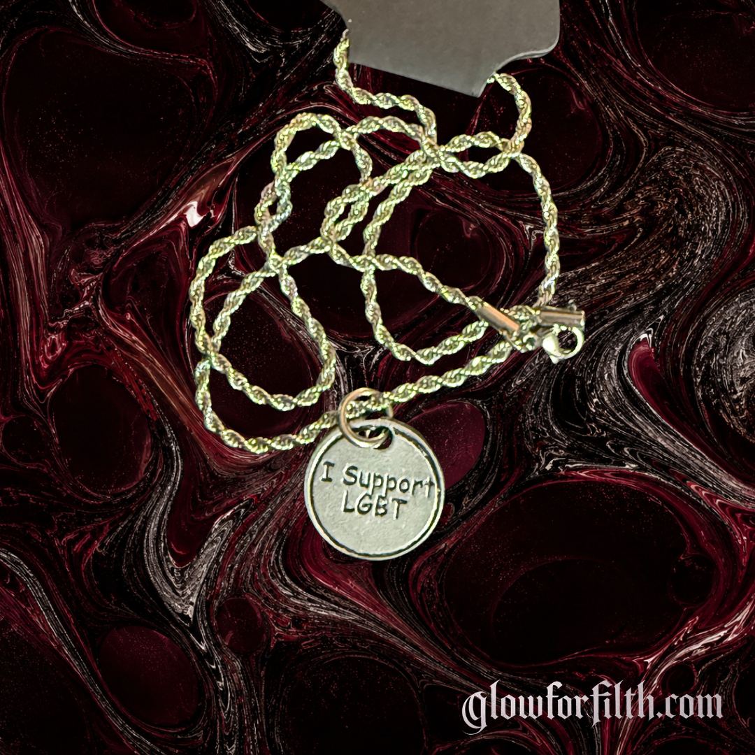 American pewter I Support LGBT charm necklace on a silver-tone rope chain displayed against a dark red and black Glow for Filth background.