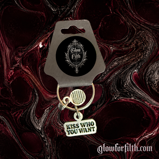 Silver-tone keychain featuring a lead-free pewter Kiss Who You Want charm displayed on a burgundy and black gothic background.