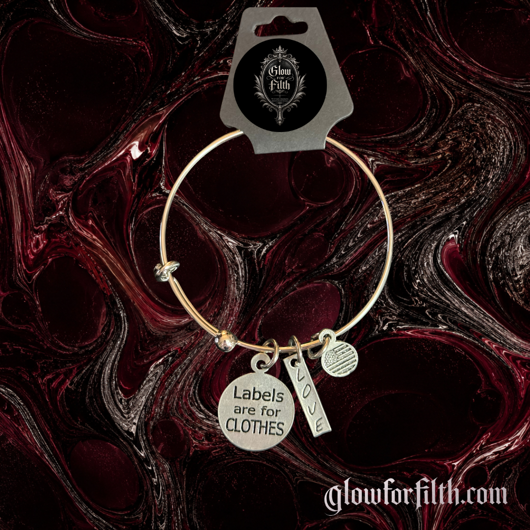 Silver-tone adjustable bangle bracelet featuring Labels Are for Clothes and LOVE pewter charms displayed on a gothic burgundy and black background.